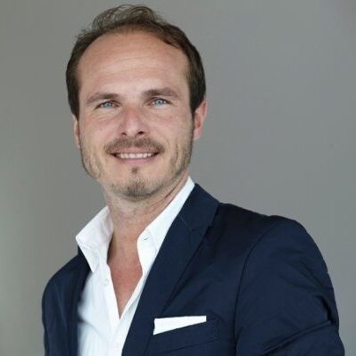 Alexander Kuster im Businessdress lächelt in die Kamera