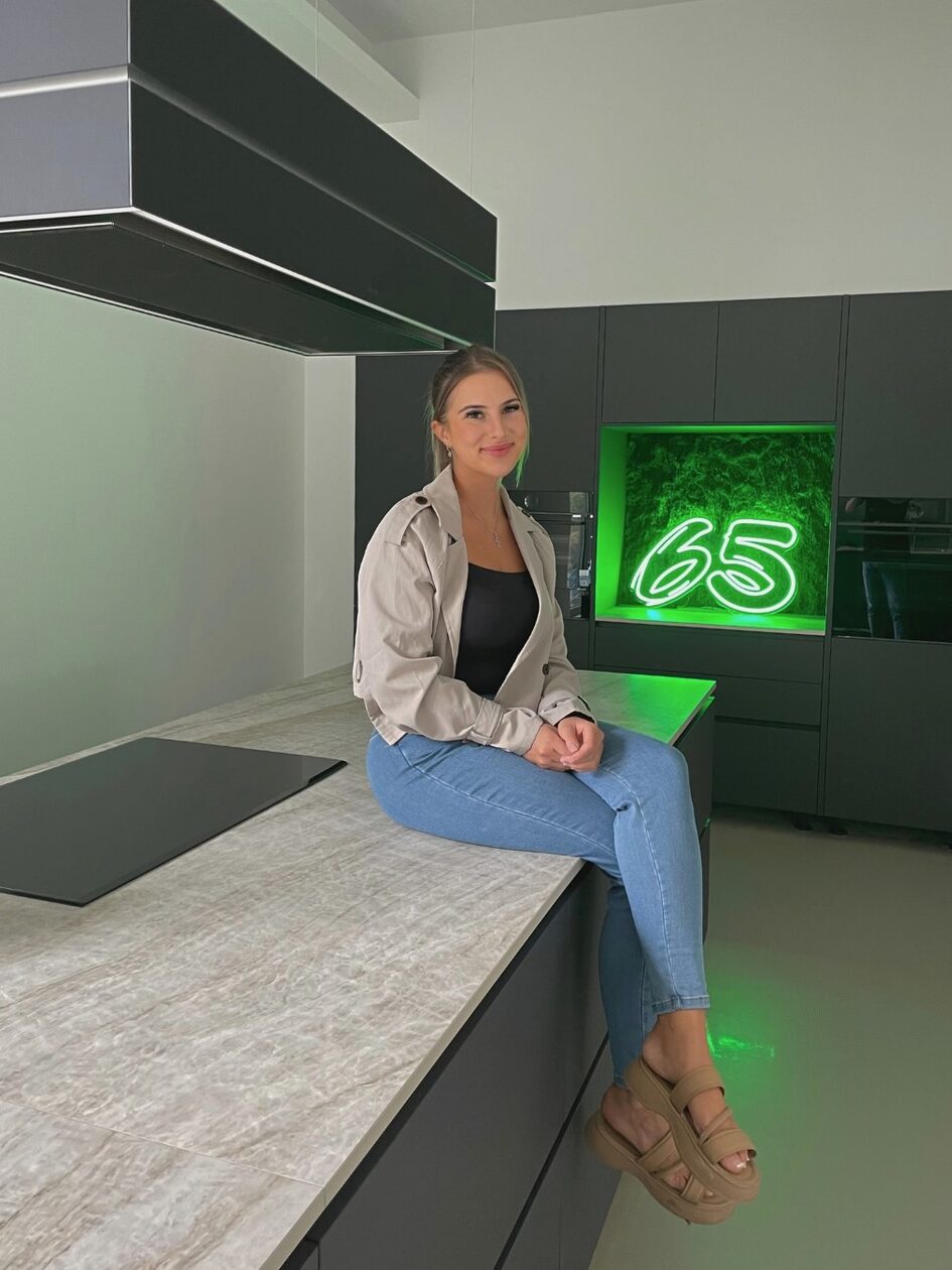 امرأة تجلس على جزيرة المطبخ وتبتسم للكاميرا