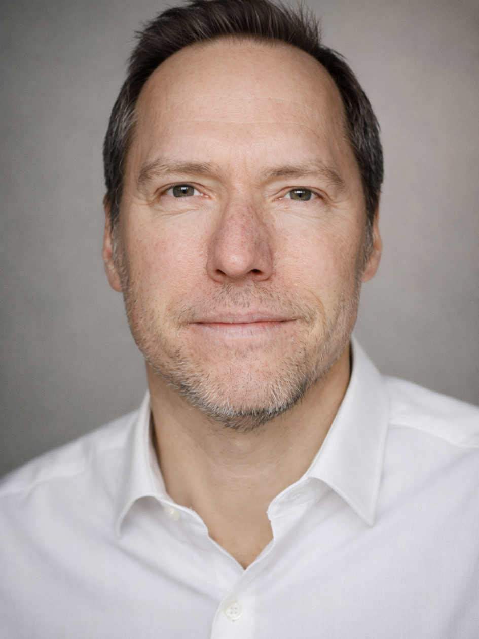 Beyaz gömlekli adam kameraya bakıyor