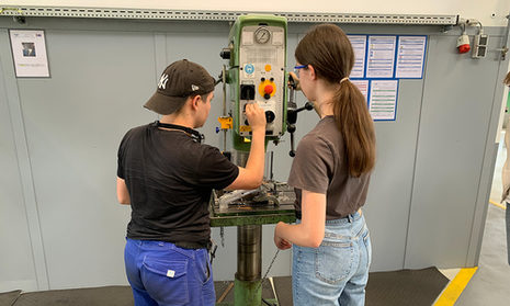 Zwei Jugendliche vor einer Maschine