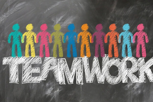 Teamwork als Slogan und vielen bunten Männchen.