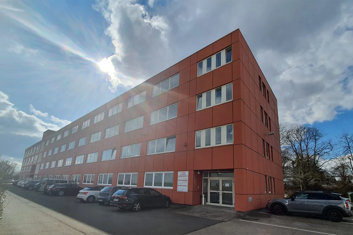 Bürogebäude, davor parken Autos.