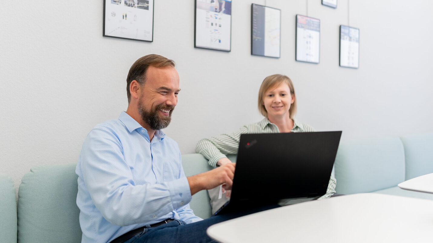 Uomo e donna seduti davanti a un computer portatile