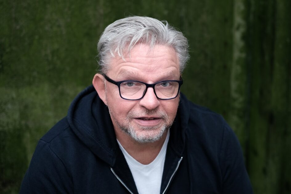 Mann mit Brille schaut offen in die Kamera